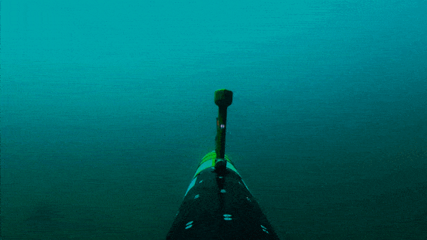 A drone attached to a vessel moving underwater.